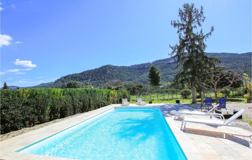 a swimming pool in a yard with chairs and trees at Beautiful Apartment In Gemenos With Outdoor Swimming Pool in Gémenos