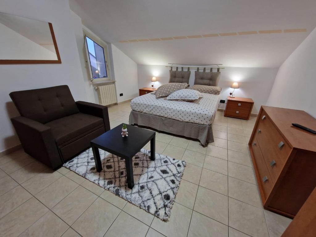 una camera con letto, sedia e tavolo di A Casa Letizia Foggia a Foggia