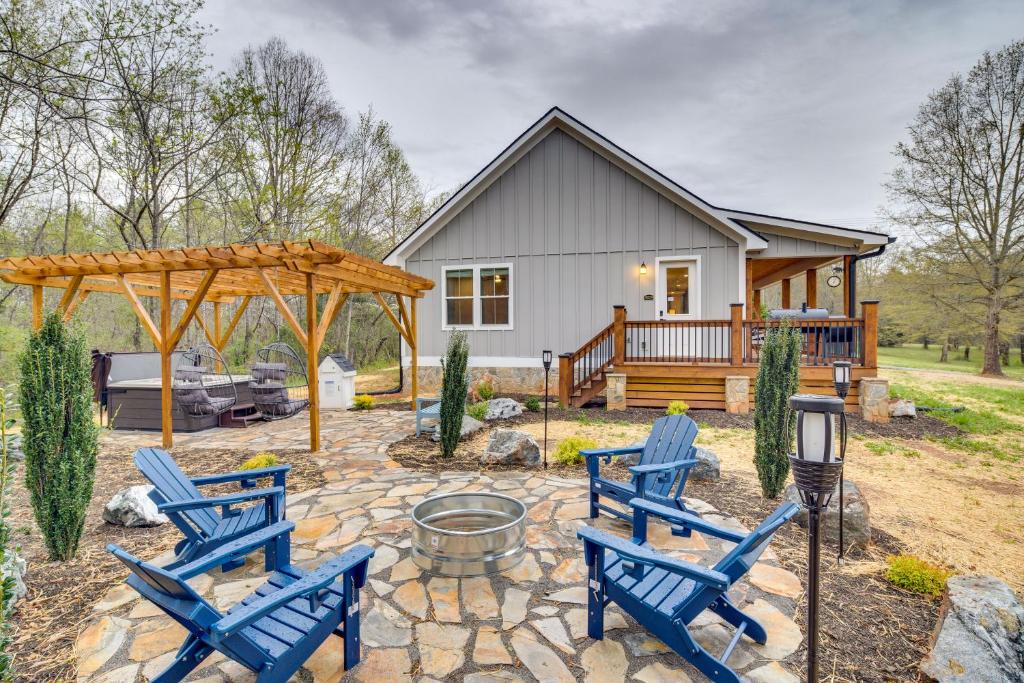 un patio trasero con sillas azules y una hoguera en Upscale Rutherfordton Vacation Rental with Hot Tub, en Lake Lure