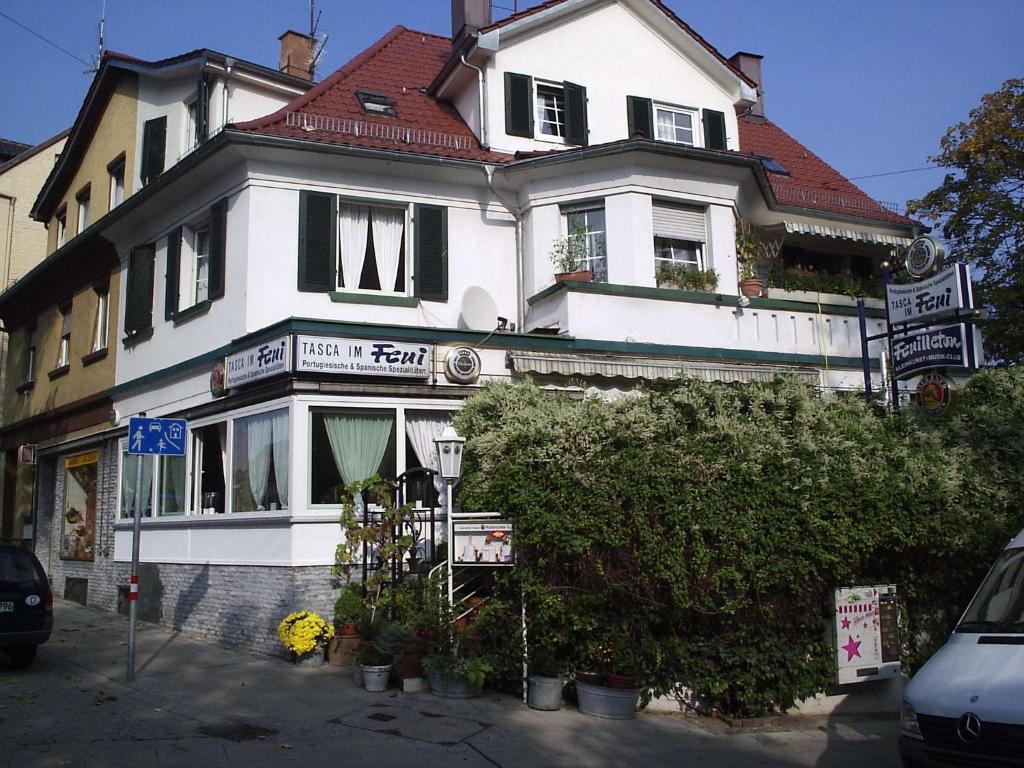 a large white house with a red roof at Tasca im Feui Apartments in Stuttgart