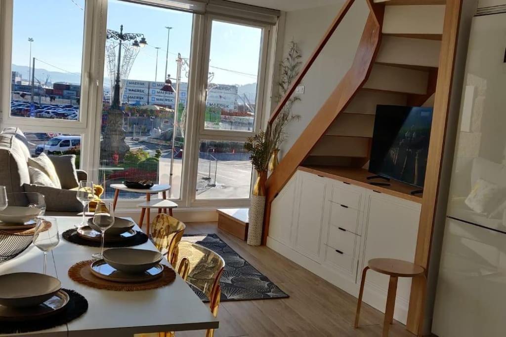 ein Wohnzimmer mit einer Treppe und einem großen Fenster in der Unterkunft Apartamento Almuiña in Marín