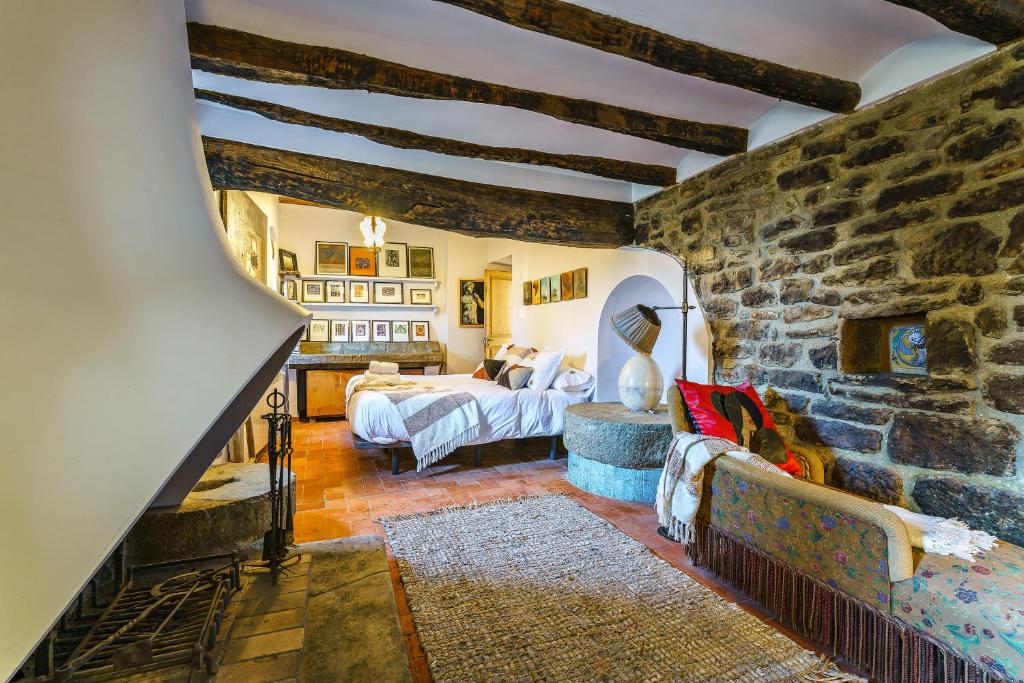 sala de estar con pared de piedra en Masia de Queralt Luxury Casa Rural Spa y Vistas, en Concabella