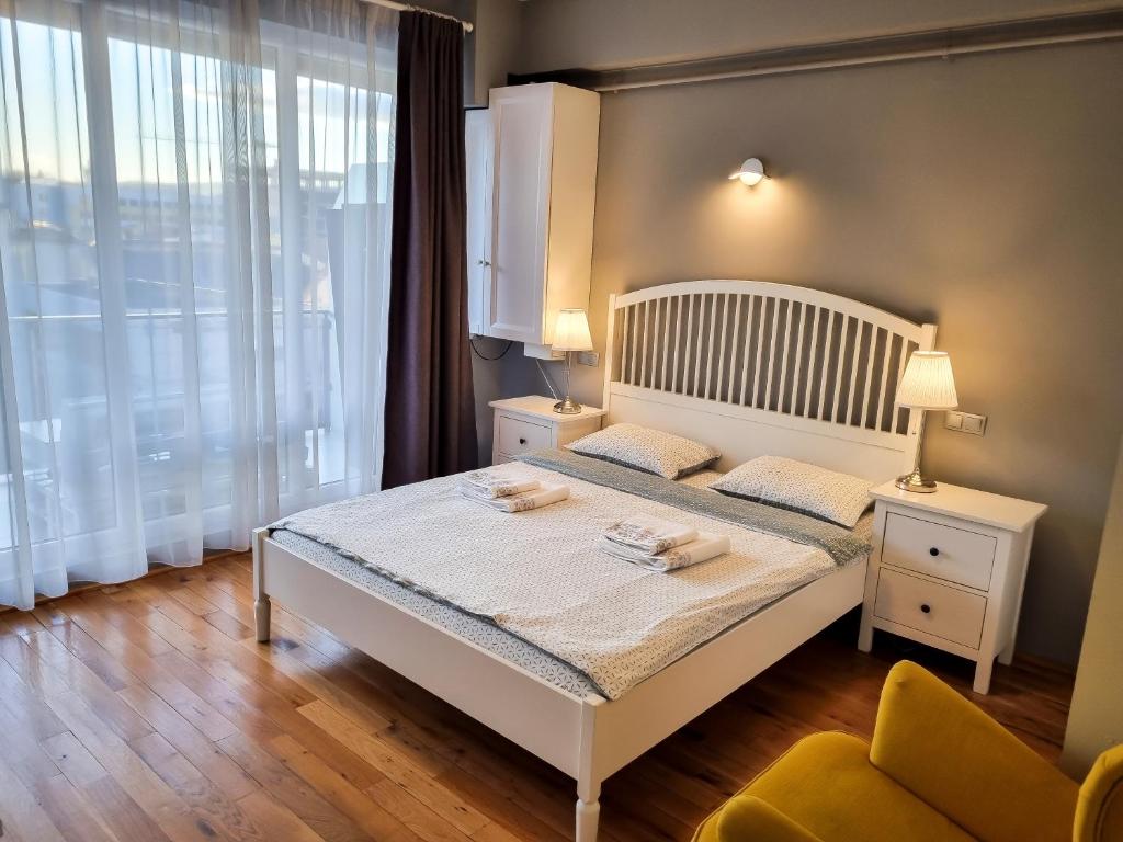 a bedroom with a white bed and a window at Traian Apartment - Cluj in Cluj-Napoca