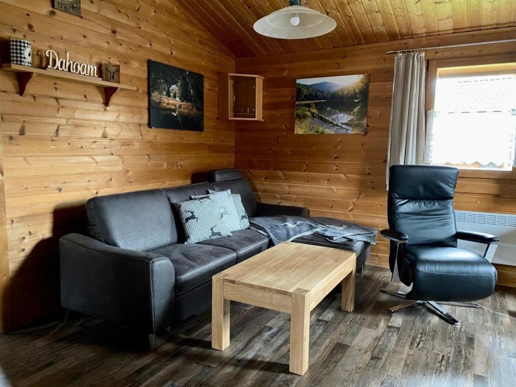 a living room with a couch and a coffee table at Ferienhaus Nr 6, Typ A, Feriendorf Jägerpark, Bayerischer Wald in Viechtach