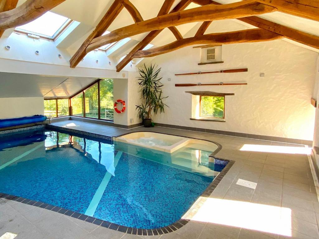 a large swimming pool in a house with a ceiling at Ysgubor Isaf in Llanglydwen