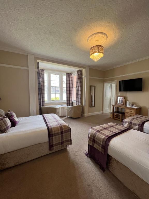 a hotel room with two beds and a television at Glentower Lower Observatory in Fort William