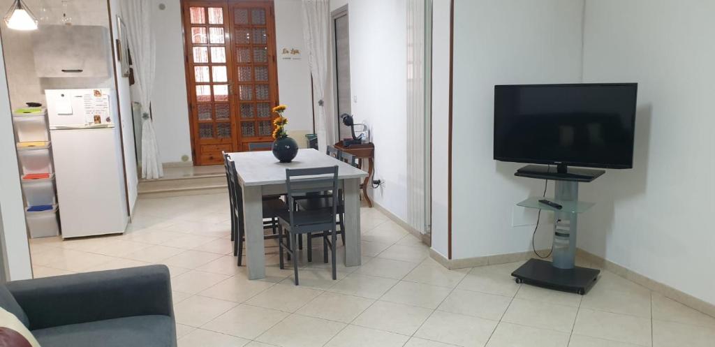un soggiorno con tavolo e TV e una cucina di Da lulù a Polignano a Mare