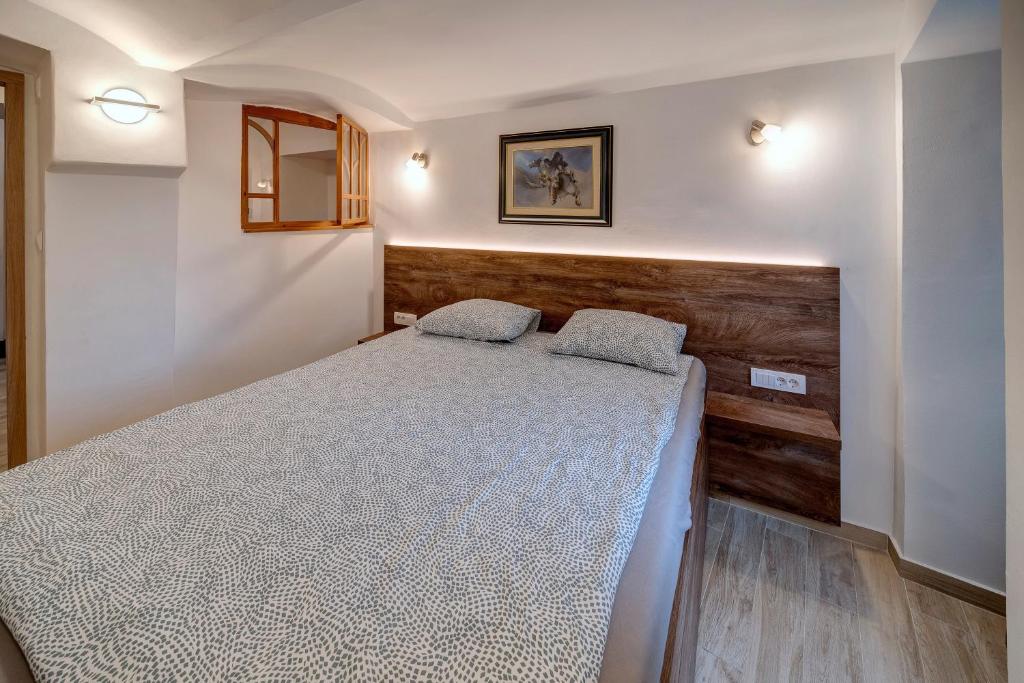 um quarto com uma cama e uma cabeceira em madeira em Apartment Vrabac, Kosančićev Venac em Belgrado