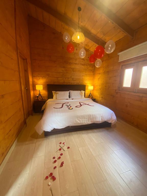 una camera da letto con letto in una camera in legno di أكواخ وشاليهات باشن الريفية a Khalij Salman