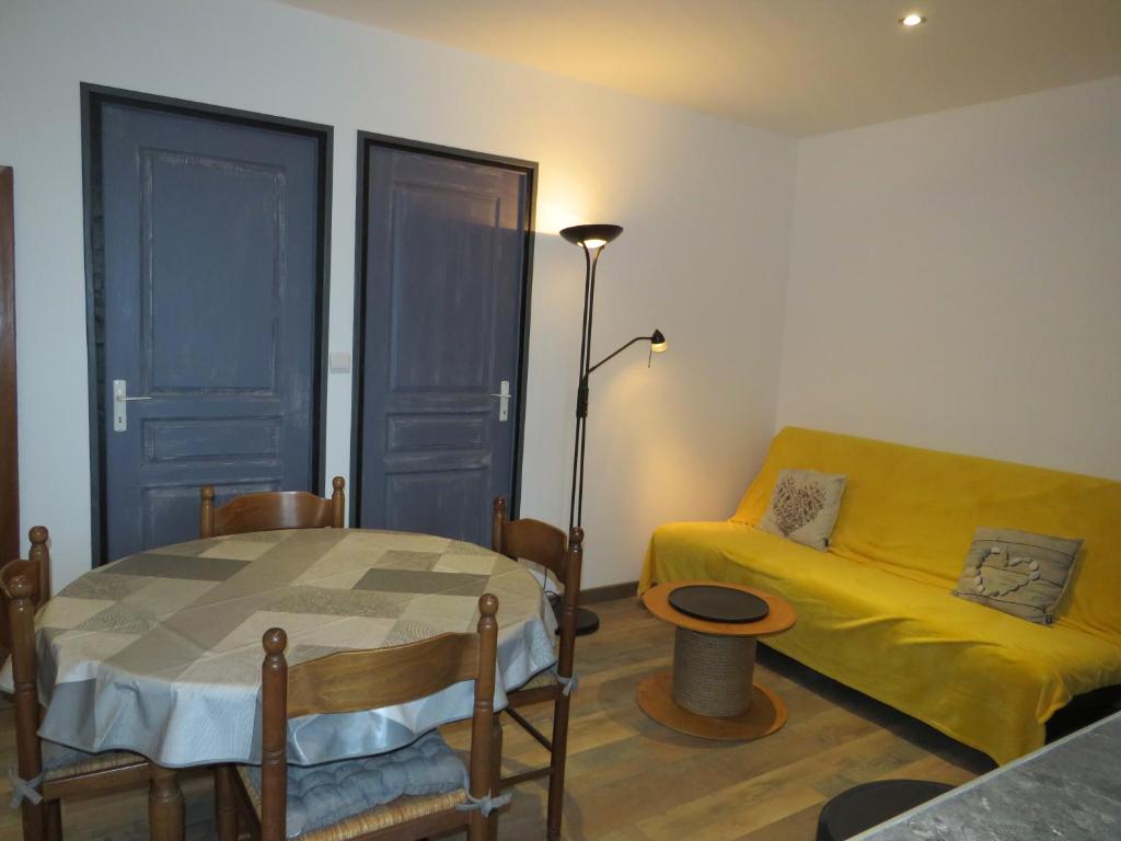 un salon avec une table et un canapé jaune dans l'établissement chez Mirka 2 chambres, à Criel-sur-Mer