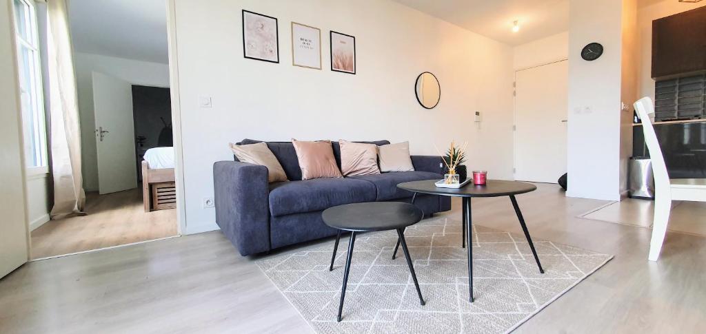 a living room with a blue couch and a table at LOTUS- 4 min de Walt Disney-Arrivée autonome-Parking et Wifi gratuit-Proche de toutes commodités 5Min de la vallée village in Chessy
