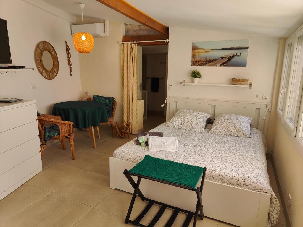 Un pequeño dormitorio con una cama y una mesa. en Petite étoile de Mer - Studio hyper équipé à 150m d'une plage de sable fin grande terrasse presqu'île de charme, en Saint-Mandrier-sur-Mer