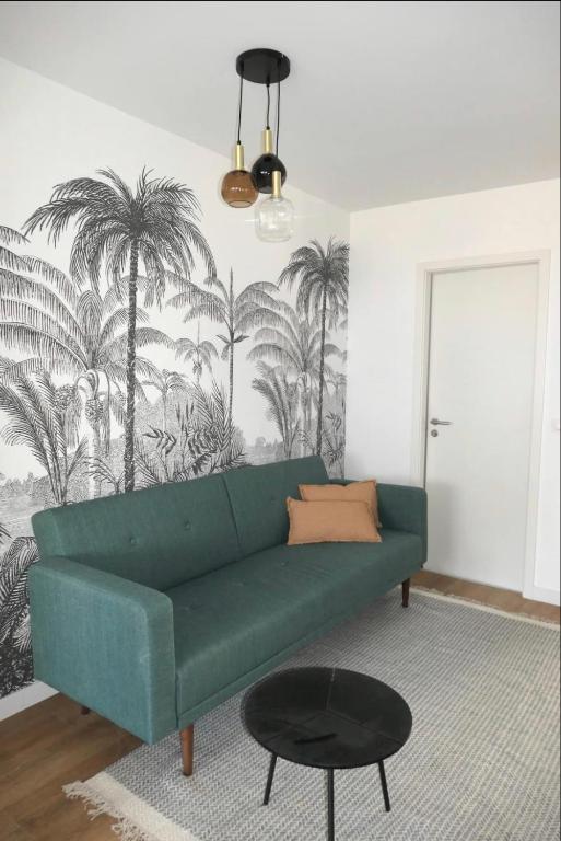 a living room with a green couch and palm trees mural at M007-8-9 Marquer Chambre colocation proche de la Gare in Annemasse
