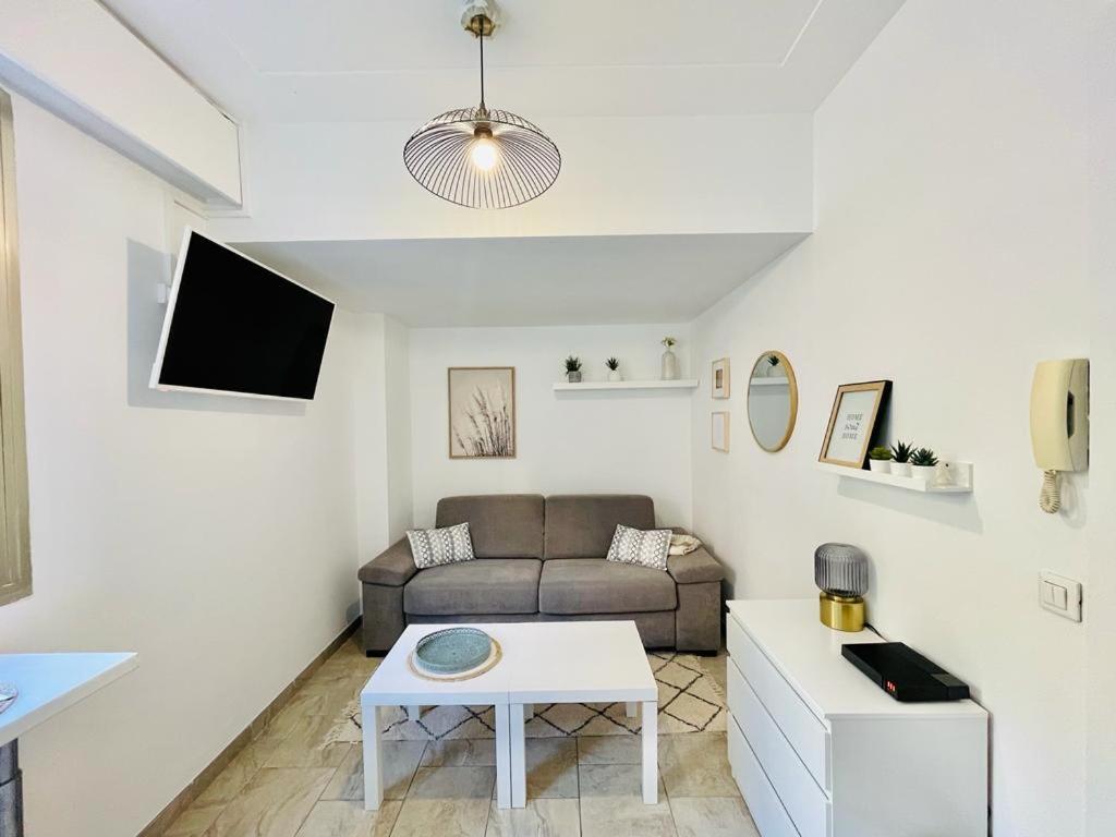 un soggiorno con un divano e un tavolo di Studio au bord de mer 1 a Mentone