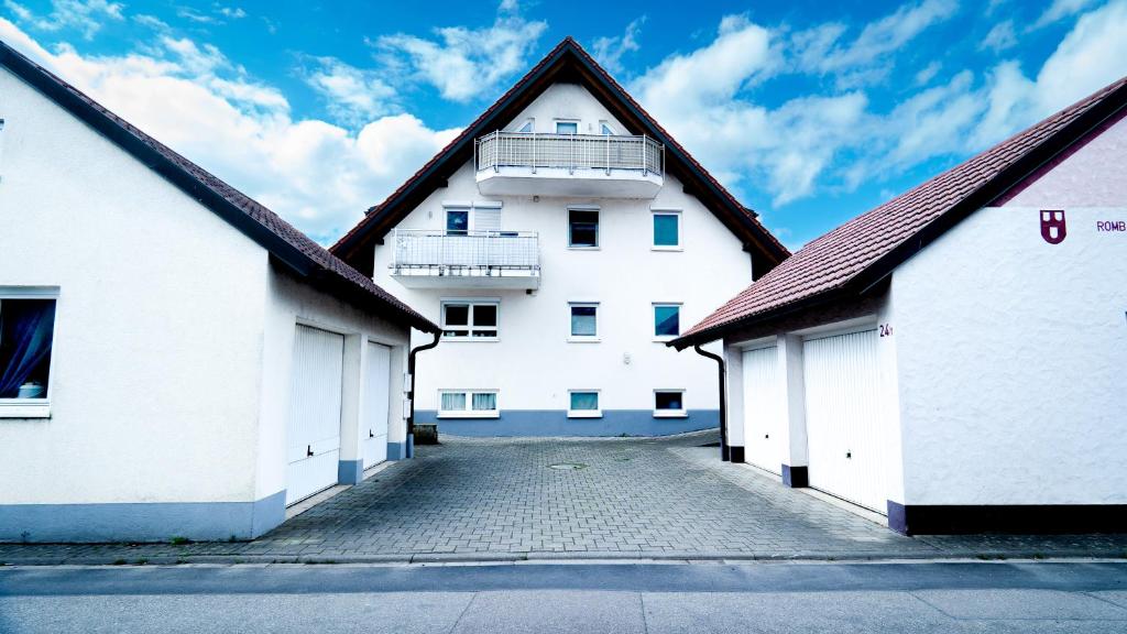een wit gebouw met een balkon erboven bij FeWo WOW II Schöne 2-Zimmer Maisonette Wohnung in Weisweil