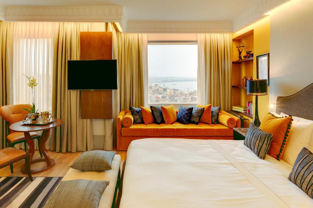 een woonkamer met een groot bed en een bank bij Ravouna 1906 Bosphorus Istanbul in Istanbul