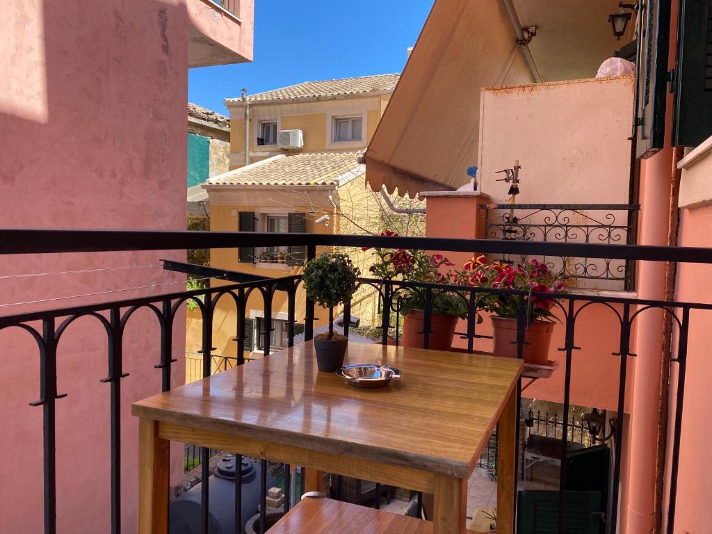 a wooden table on a balcony with a view of a city at Chrysa's apartment in Anemómylos