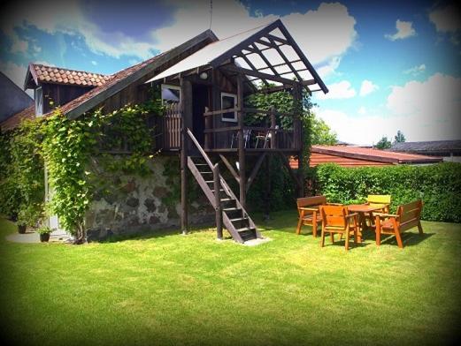 een huis met een terras en een tafel en stoelen bij Zacisze in Warpuny