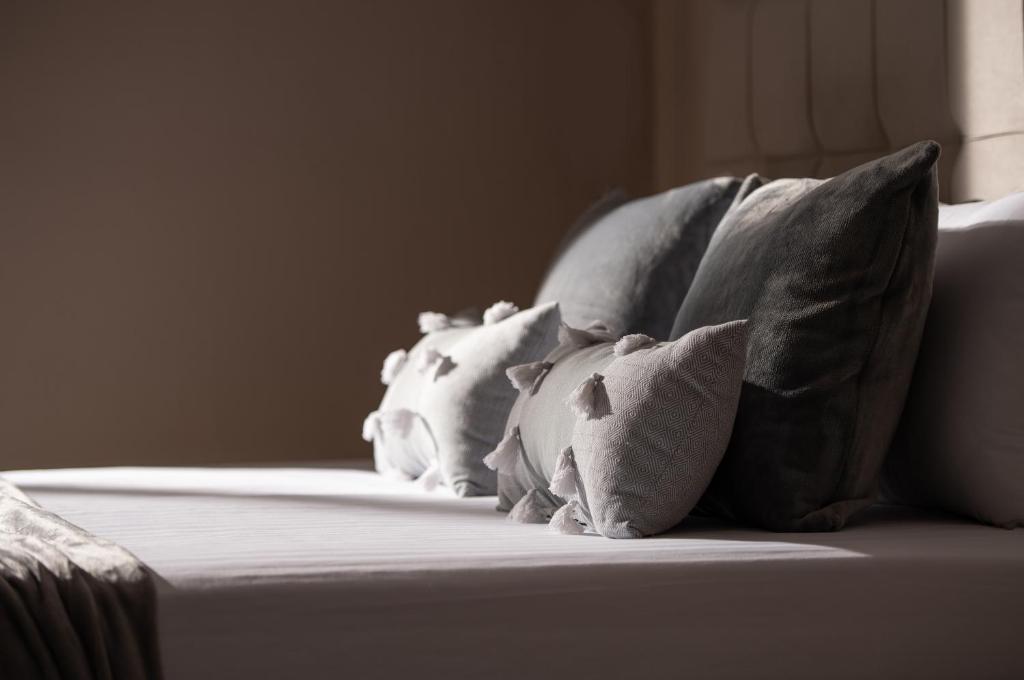 grupa poduszek siedzących na łóżku w obiekcie theodoroula house w mieście Sarti