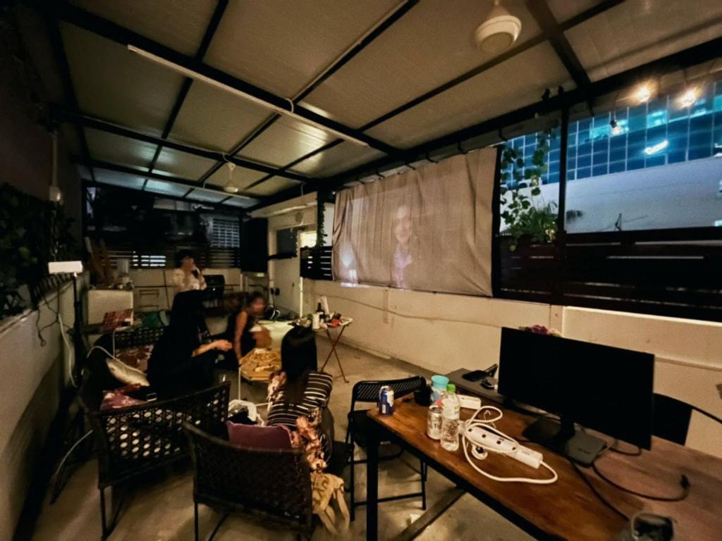 a group of people sitting in a room with a television at Digital Nomad House KL Bukit Bintang - Self service shared bathroom apartment in Kuala Lumpur