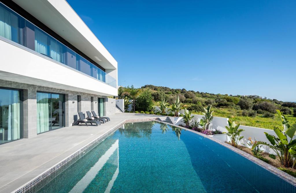 a swimming pool in front of a house at Vila Luna B&B in Lagos