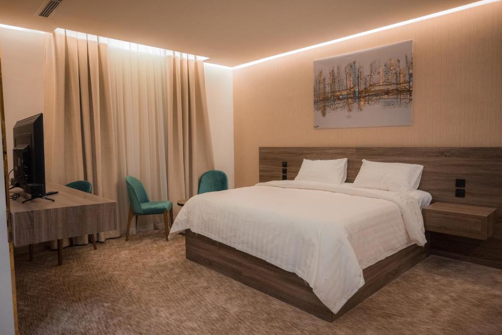 a bedroom with a bed and a desk and a television at فندق بلاتينيوم الاولي الفندقية in Al Madinah