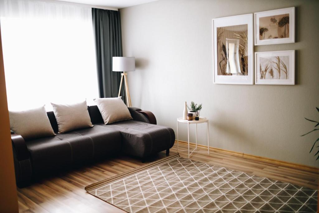 een woonkamer met een leren bank en een tapijt bij LK Apartment in Rēzekne