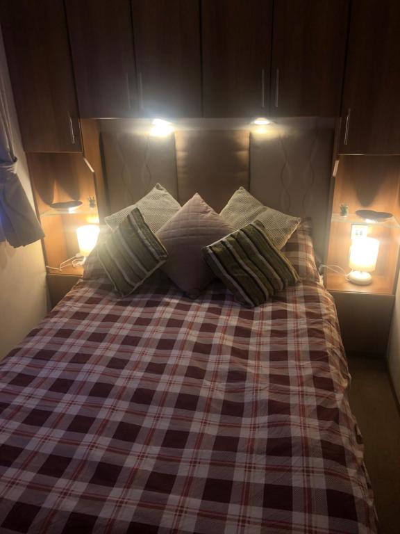 a bed with two pillows on it with two lights at First Steps Caravan Rentals in Sandown