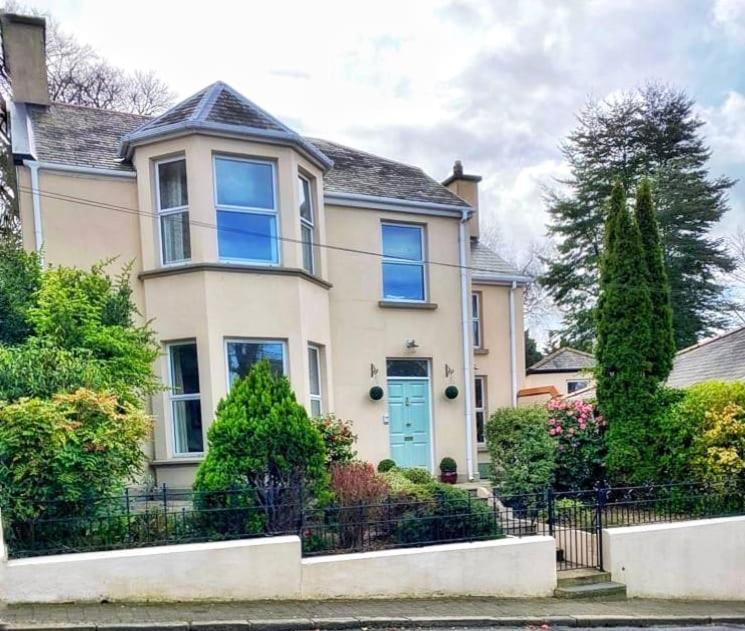 Una gran casa blanca con una puerta azul en Victorian Villa en New Ross