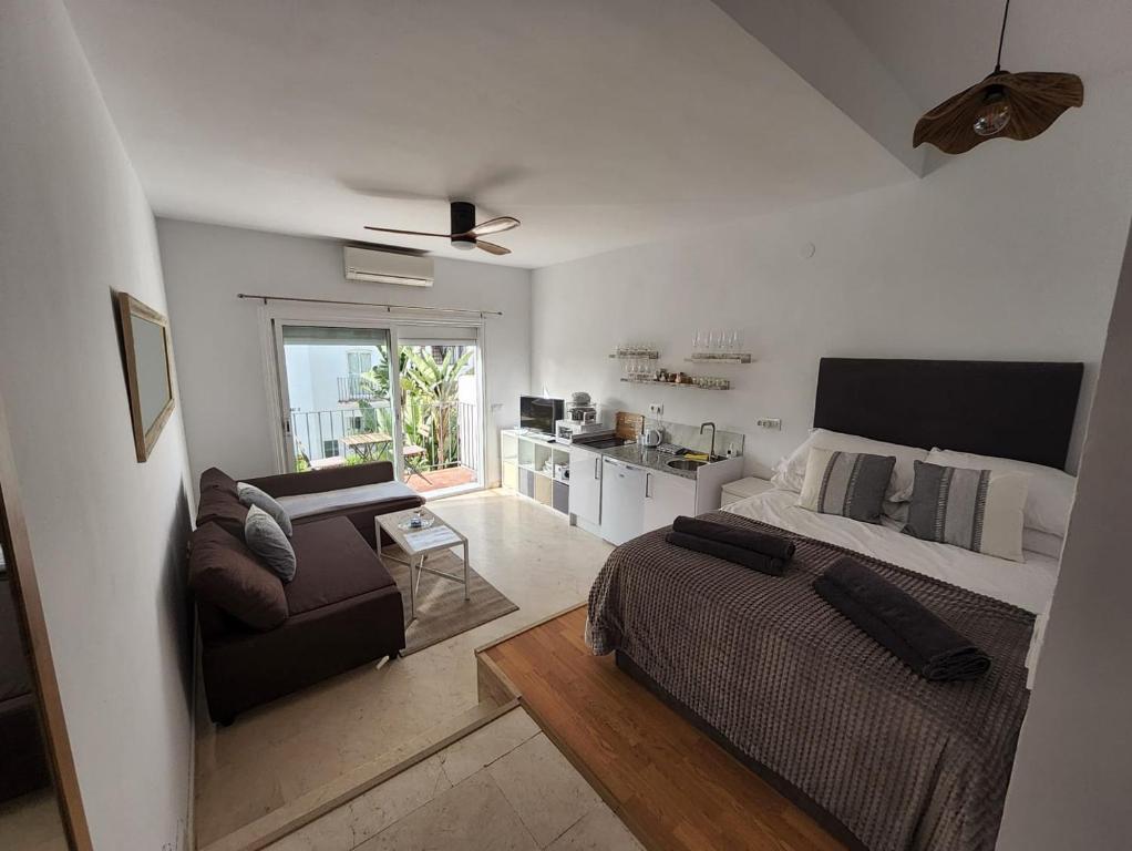 a bedroom with a bed and a couch and a kitchen at Tranquility studio apartment in Málaga