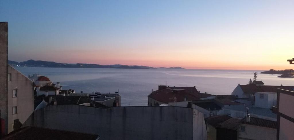a view of the ocean from a city at sunset at Apartamento BELA VISTA in Sanxenxo