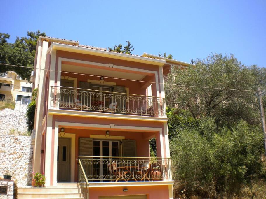 a building with a balcony with people on it at IRIDA VILLA in Ayia Evfimia
