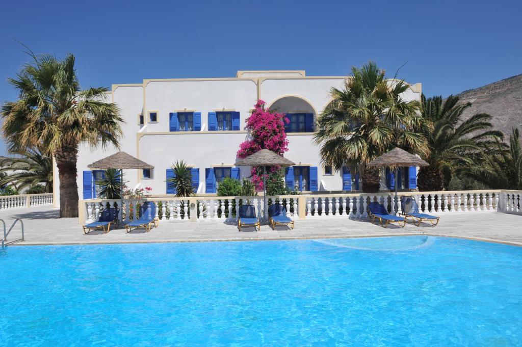 un hôtel avec une piscine en face d'un bâtiment dans l'établissement Nikolas Villas, à Perivolos