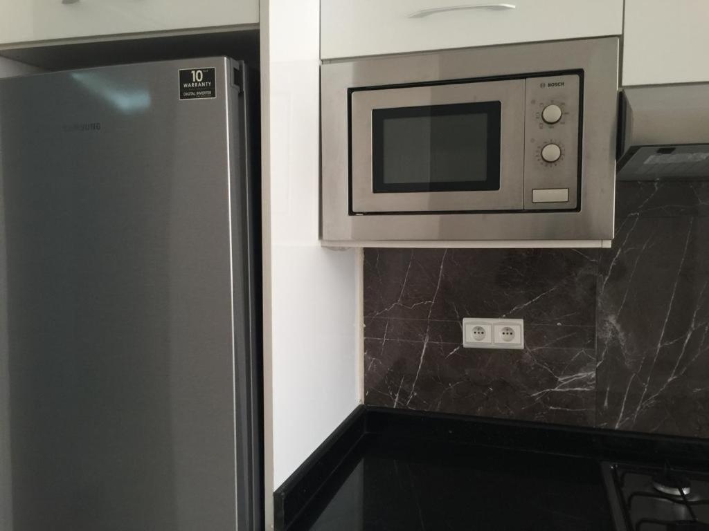 eine Mikrowelle über einem Kühlschrank in der Küche in der Unterkunft Appartement à casablanca in Tafza