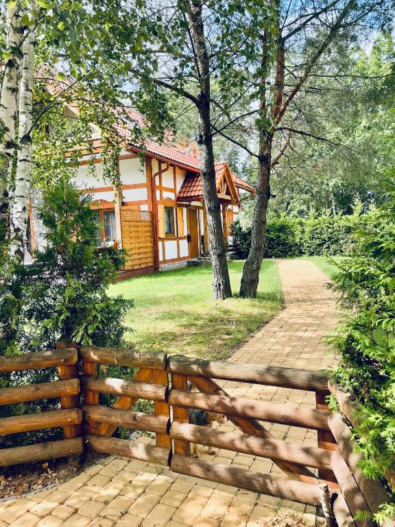 una valla de madera frente a una casa en Happy House - Kaszubska Ostoja, en Barkocin