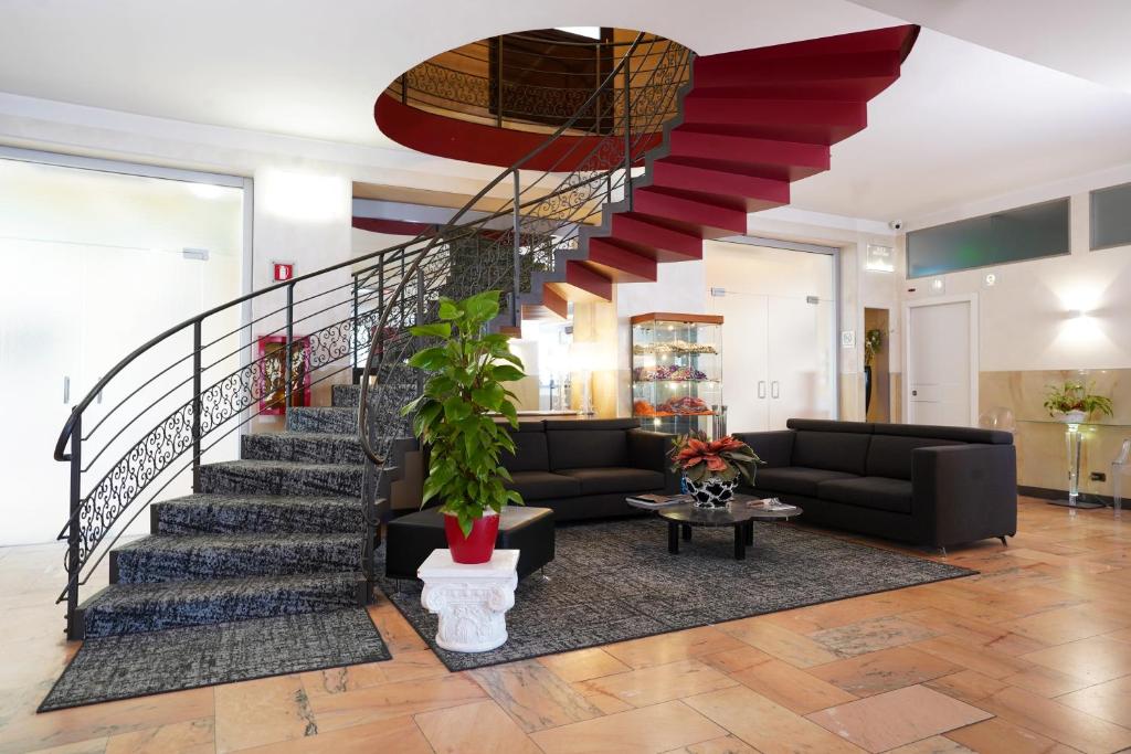 sala de estar con escalera y sofá en Hotel Plaza en Turín
