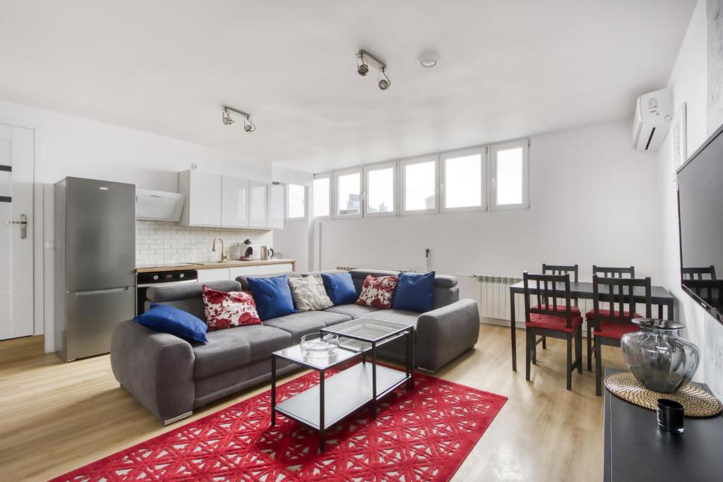 - un salon avec un canapé et un tapis rouge dans l'établissement Central Family Apartment, à Varsovie