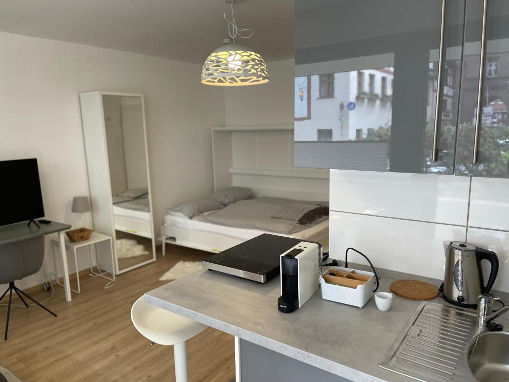 a kitchen with a counter with a bed in the background at Altstadtoase an der Marientormauer in Nuremberg