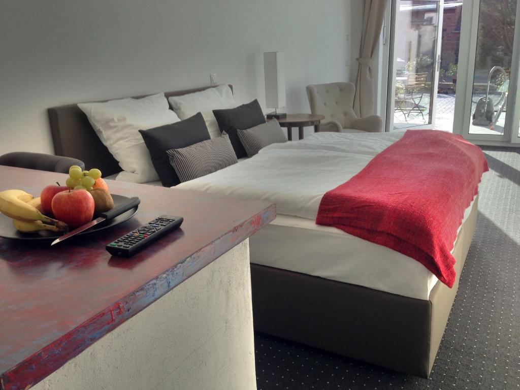 Un dormitorio con una cama y una mesa con fruta. en Aparthotel Flughafen Leipzig, en Freiroda