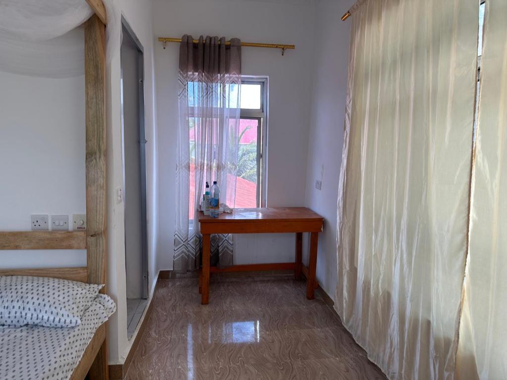 a small room with a table and a window at Kijiji House Paje in Paje