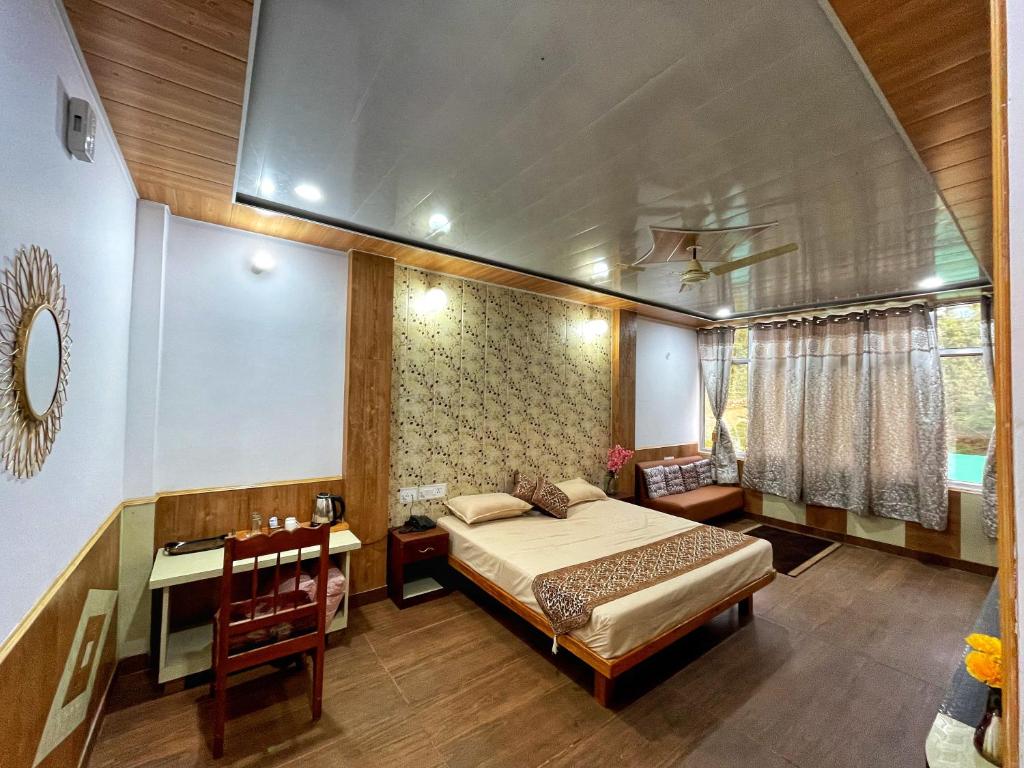 a bedroom with a bed and a table and a desk at Plaza Hotel in Pithorāgarh