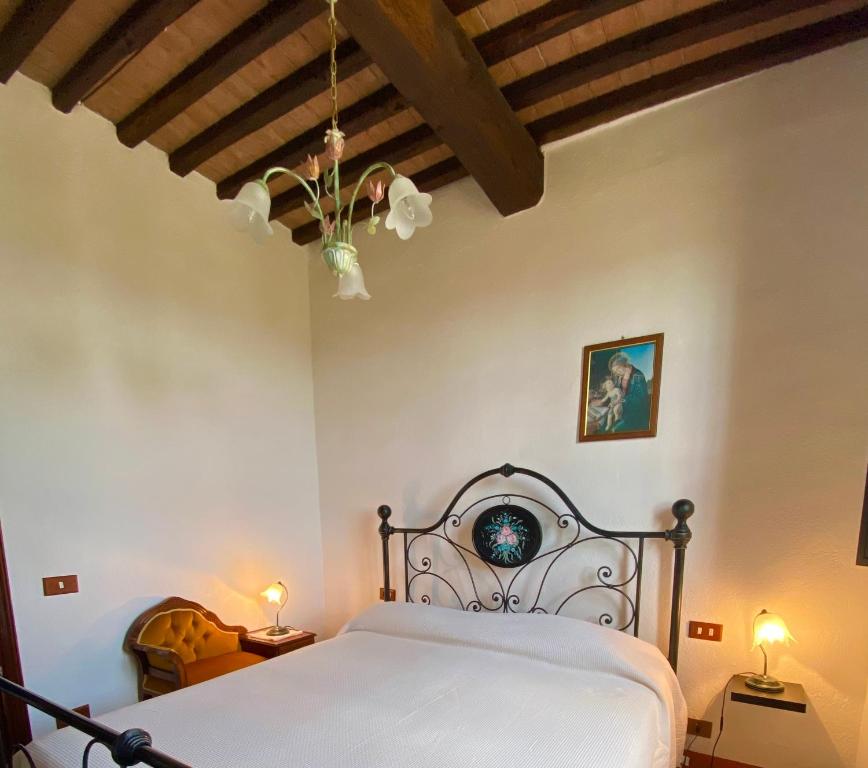 um quarto com uma cama branca e 2 candeeiros em Villa Cresci con piscina em Sassetta
