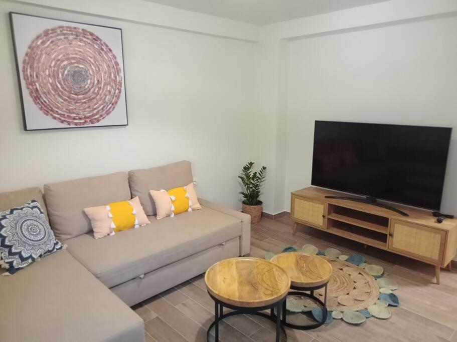 a living room with a couch and a flat screen tv at 'ΟΜΟΡΦΟΣ ΧΩΡΟΣ ΣΤΙΣ ΑΛΥΚΕΣ ΒΟΛΟΥ in Volos