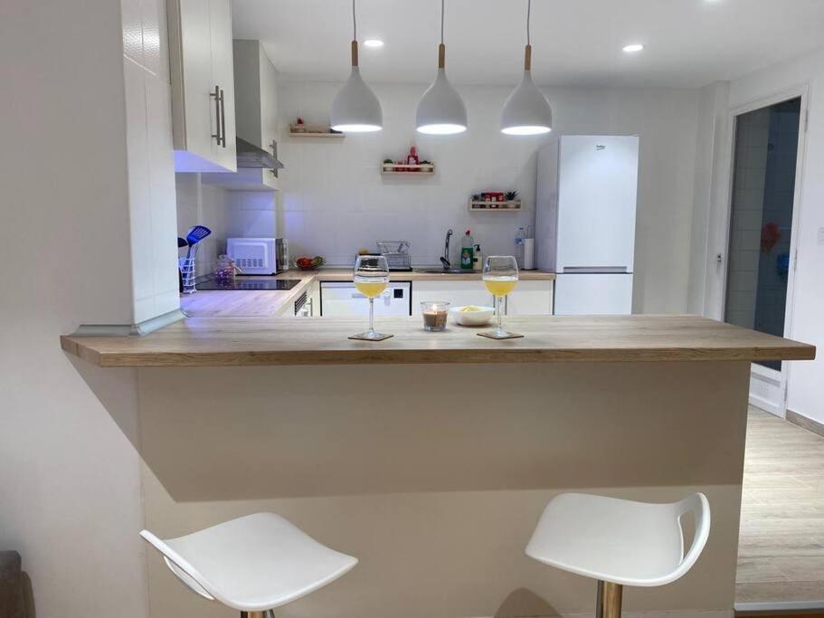 una cocina con 2 copas de vino en una barra en Apartamento Playa Levante, en Santa Pola