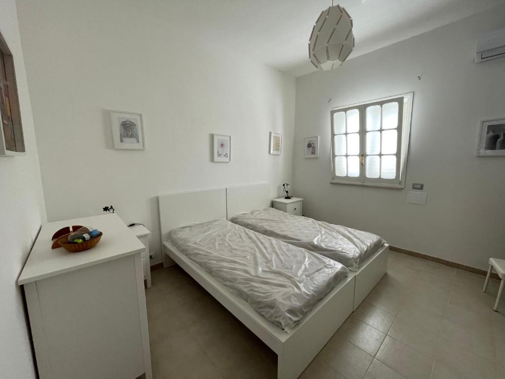 サン・ピエトロ・イン・ベヴァーニャにあるVilla Toniaの白いベッドルーム(ベッド1台、窓付)
