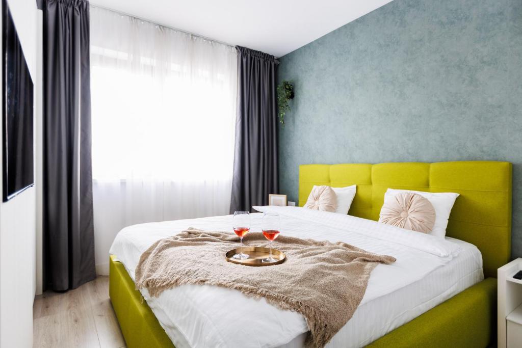 a bedroom with a large bed with a yellow headboard at Vanilla Apartment - Pipera in Bucharest