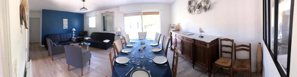 une salle à manger avec une table et des chaises bleues dans l'établissement Agréable maison familiale Proche De l'Océan Grand jardin, à Arthon-en-Retz