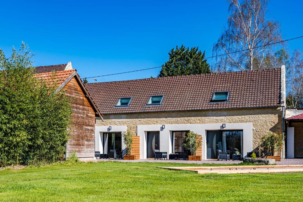 une maison en briques avec une pelouse devant elle dans l'établissement L’orne, à Caen