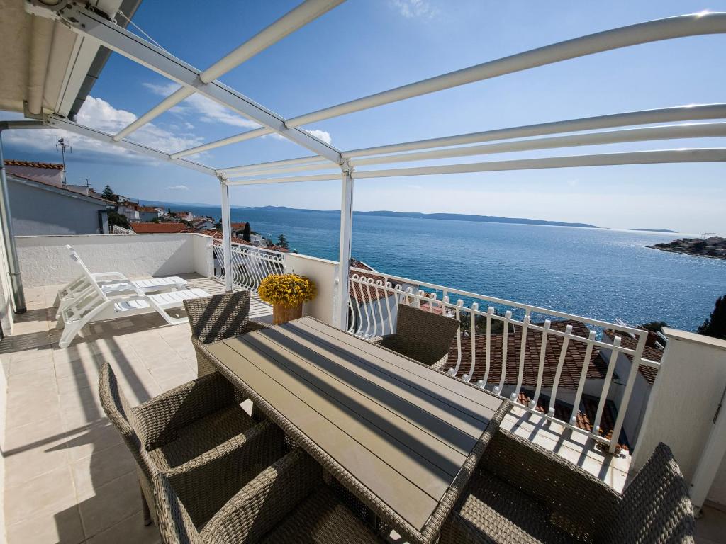balcón con banco y vistas al océano en Apartments Cacija, en Trogir