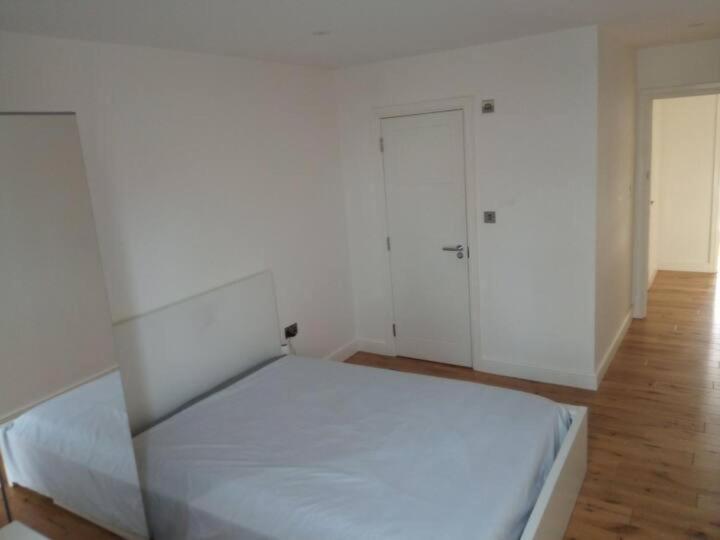 um quarto branco com uma cama e um closet em Luxury Penthouse Apartment ( Private Gated) em Londres